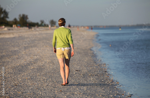 Fototapeta Naklejka Na Ścianę i Meble -  woman walking along beach