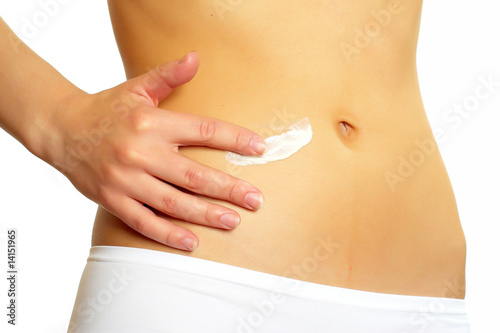Woman applying creme to her stomach