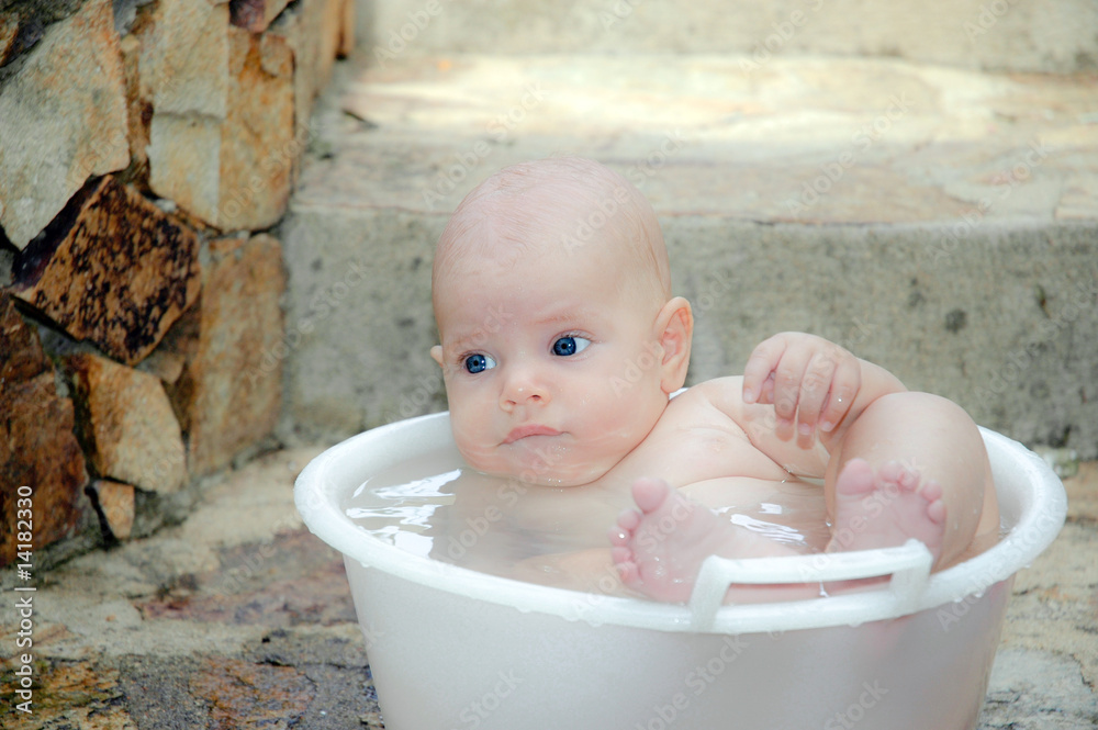 Foto Stock bagnetto di neonato in bacinella | Adobe Stock