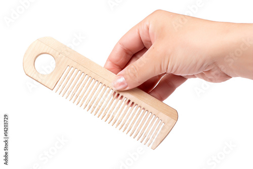 Woman's hand with wooden comb isolated on white. photo