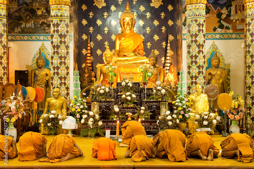 Buddhist monk praying in church photo