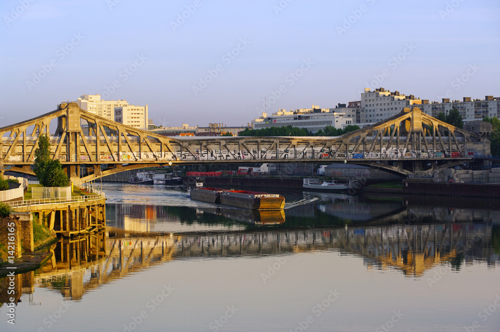 Fototapeta premium péniche sur la seine sous pont à l'entrée de paris