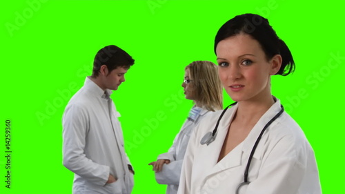 Female doctor looking at the camera with her team photo