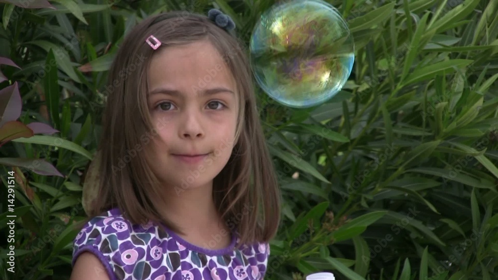 fillette soufflant une belle bulle