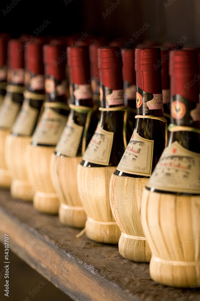 Chianti wine bottles on a rack - obrazy, fototapety, plakaty 