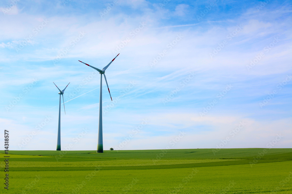 Wind turbines farm in green field over cloudy sky Wind turbines farm in green field over cloudy sky