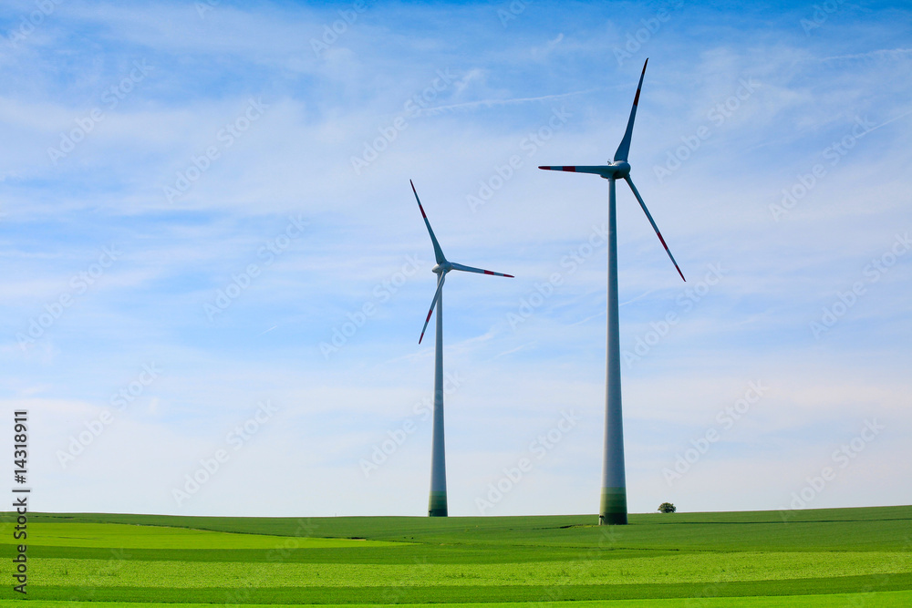 Wind turbines farm in green field over cloudy sky Wind turbines farm in green field over cloudy sky