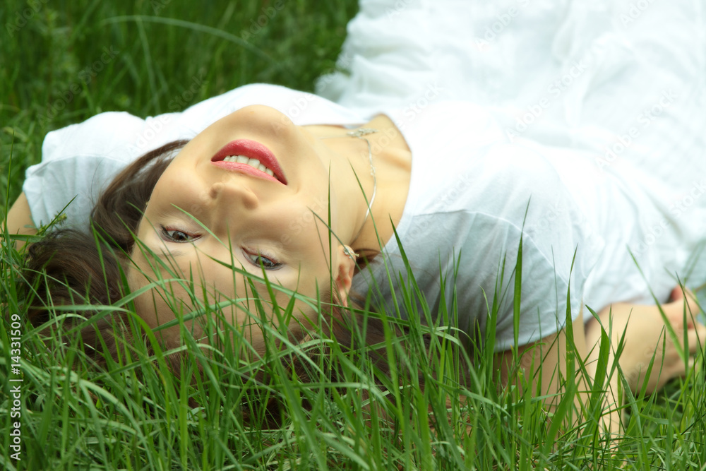 Beautiful young woman relaxing in the grass