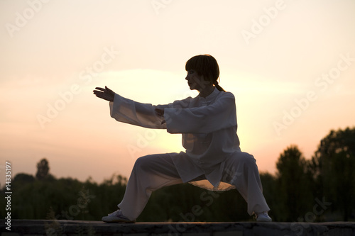Fotografia woman in white suit make's taiji chuan exercise