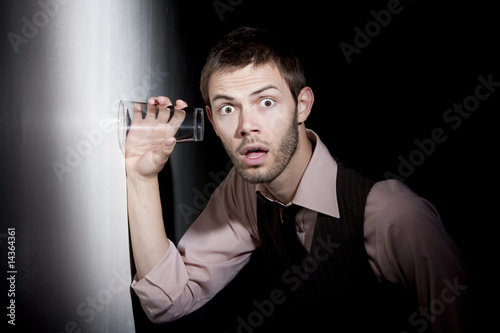 фотографія Handsome young man using glass to eavesdrop