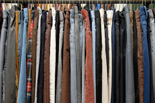 A rack of mens pants in a second hand shop