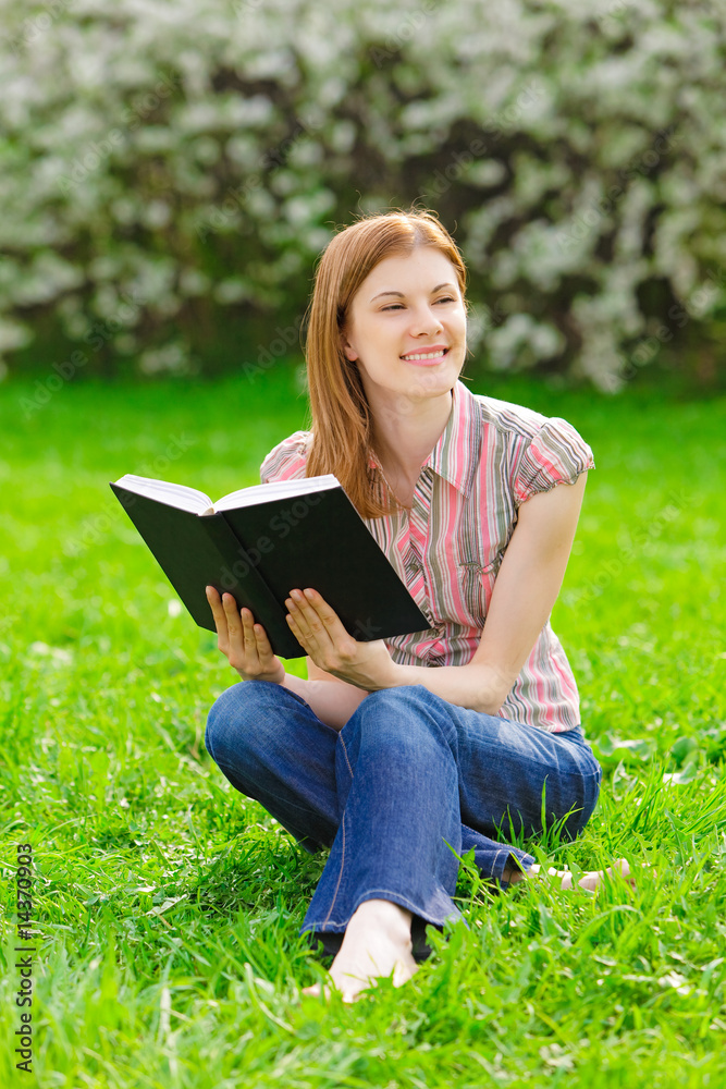 Fototapeta premium Pretty girl reading outdoors