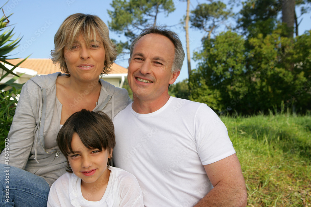 Familia sentada en el jardín de una casa Familia sentada en el jardín de una casa
