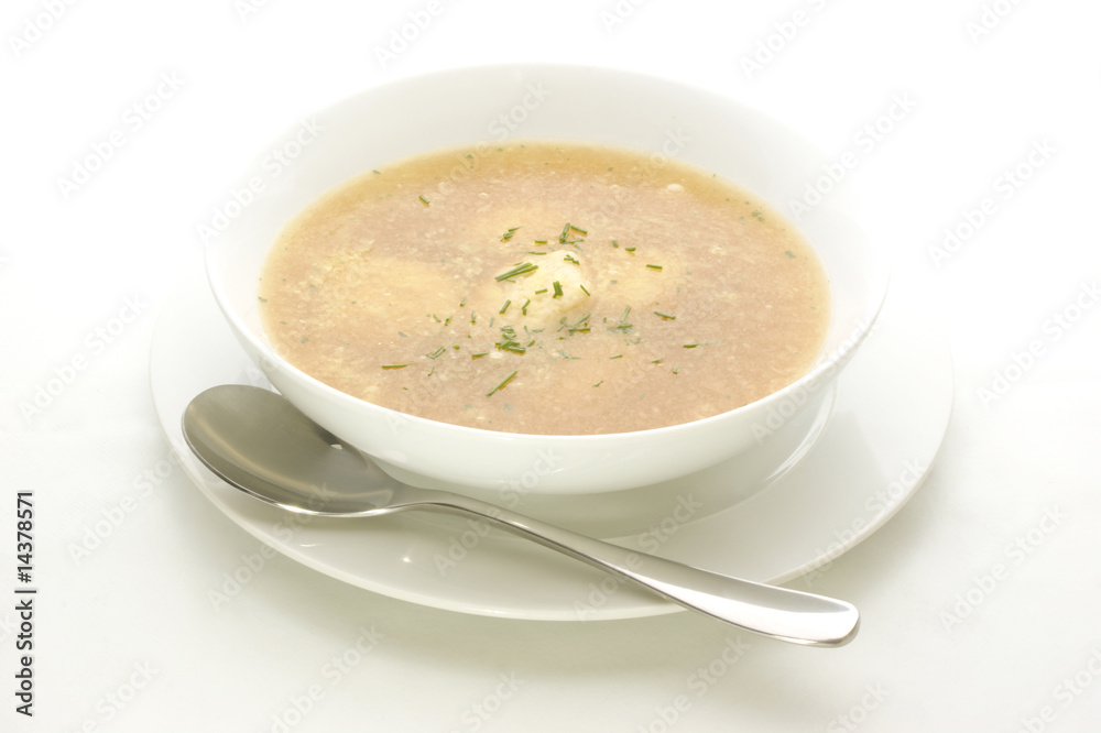 Griesskloesschensuppe in einer weissen Schale mit einem Loeffel Griesskloesschensuppe in einer weissen Schale mit einem Loeffel
