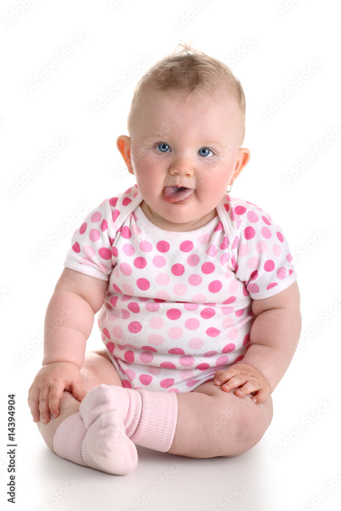 Sweet baby girl sitting and sticking out tongue Sweet baby girl sitting and sticking out tongue