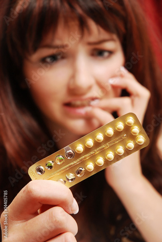 Worried woman looking at her pills