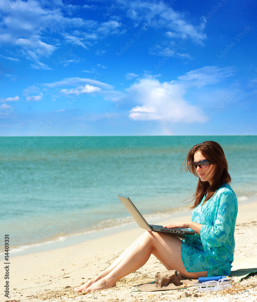 girl using a laptop near the sea