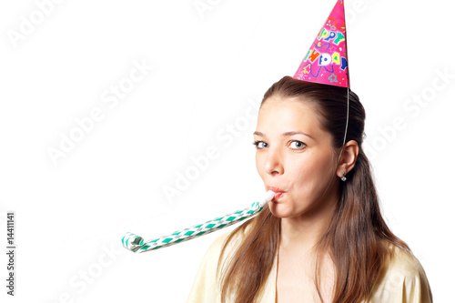 Young pretty woman in birthday cap with noisemaker