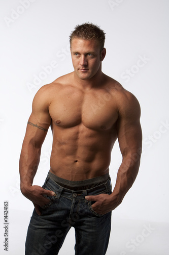 Muscle guy in jeans on white