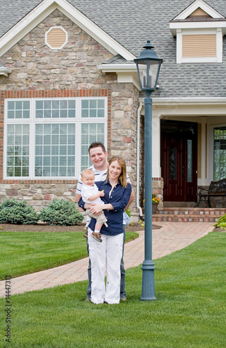 Happy Family in Front of Their Home