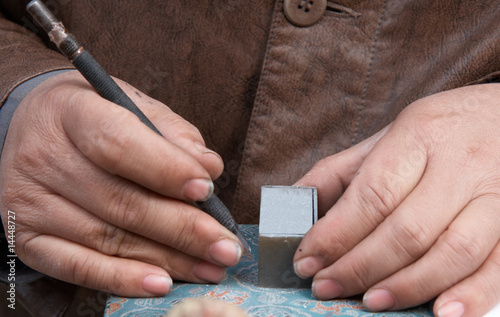 Male hand carving a stamp photo