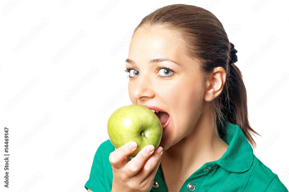Young pretty woman in green shirt eating fresh green apple Young pretty woman in green shirt eating fresh green apple