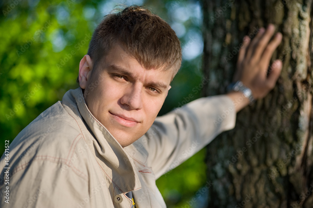 The young man holding from a tree The young man holding from a tree