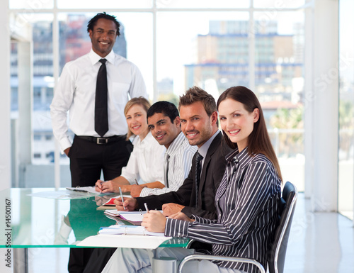 Business people in a meeting smiling at the camera
