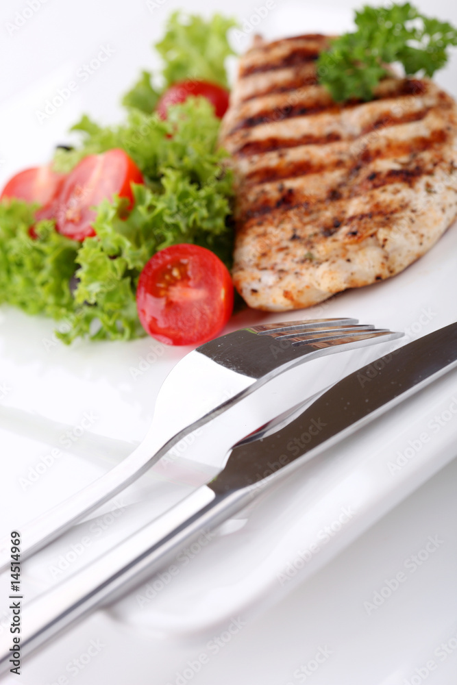 Grilled chicken breasts on a plate with fresh vegetables Grilled chicken breasts on a plate with fresh vegetables