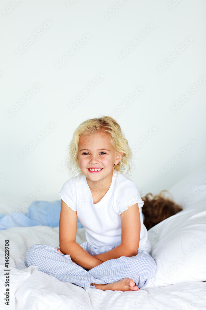 Little girl sitting in bed with copyspace Little girl sitting in bed with copyspace