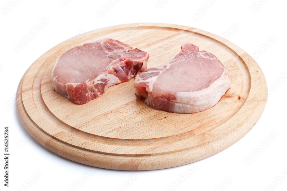 raw pork chops on chopping board