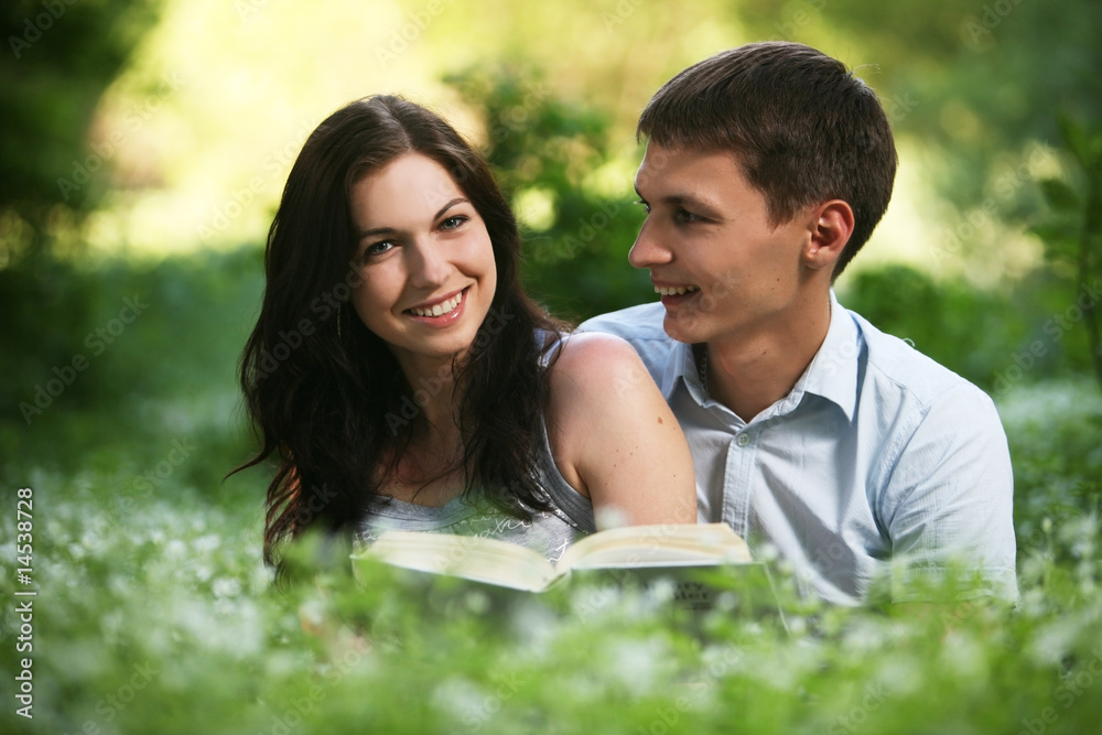 Man and woman sitting on the grass and reading. Man and woman sitting on the grass and reading.