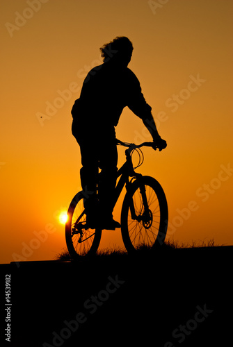 silhouet of a young adult riding a bike