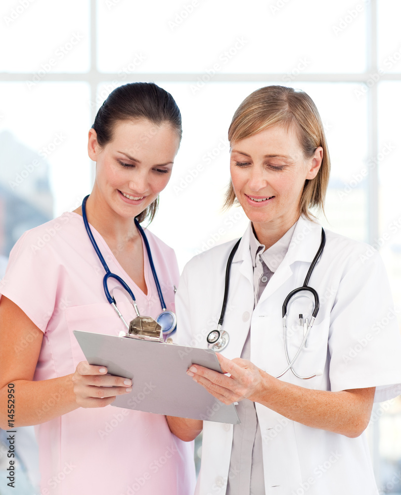 Nurse and doctor reading a medical report Nurse and doctor reading a medical report