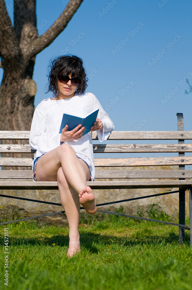 Beautiful college student sitting on garden seat on campus
