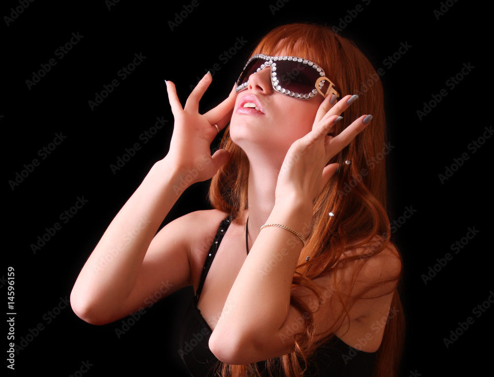 Young red head woman with sunglasses on black background Young red head woman with sunglasses on black background