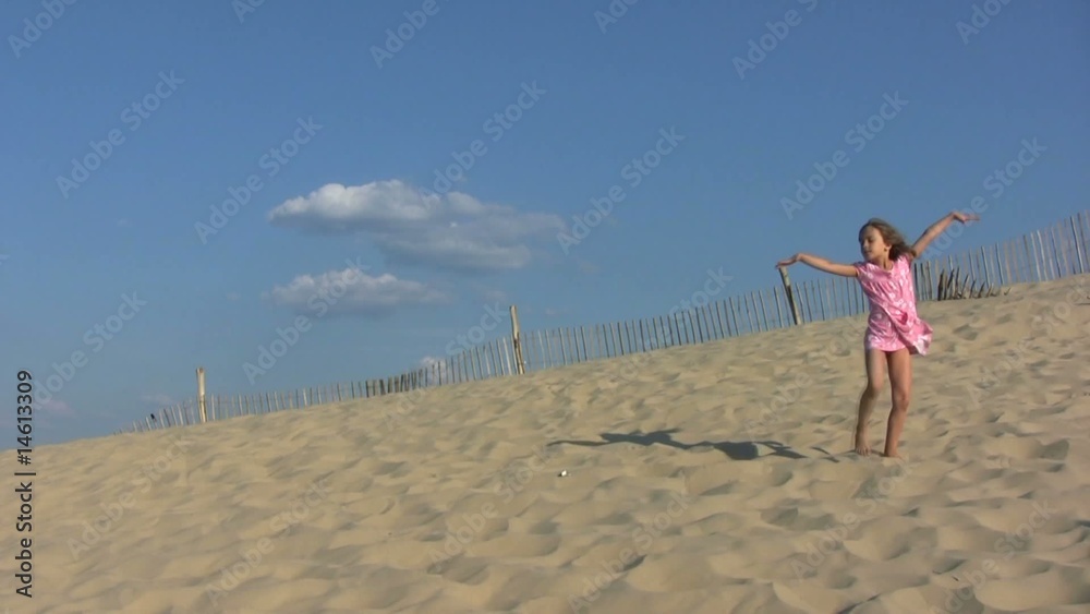 fillette dansant gracieusement au sommet de la dune