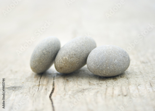 three round and soft stones on a old piece of wood