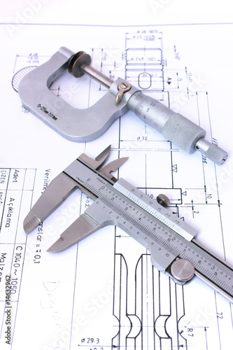 Micrometer and caliper on blueprint vertical. Shallow dof