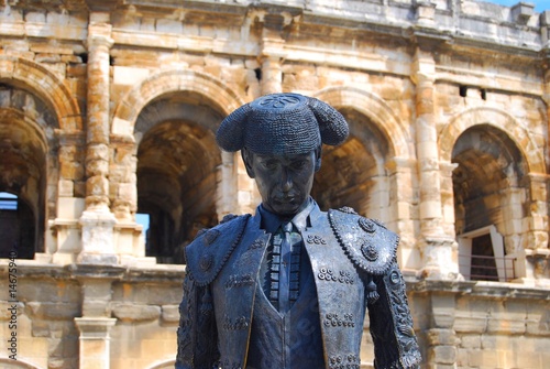 Gros plan de la statue devant les arènes de Nîmes