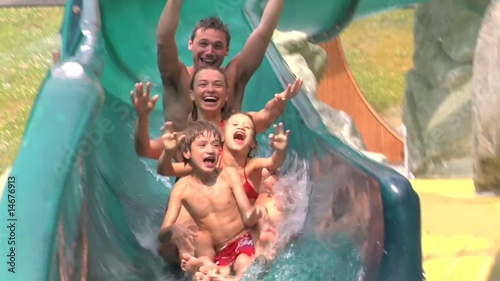 Famiglia si diverte con lo scivolo in piscina