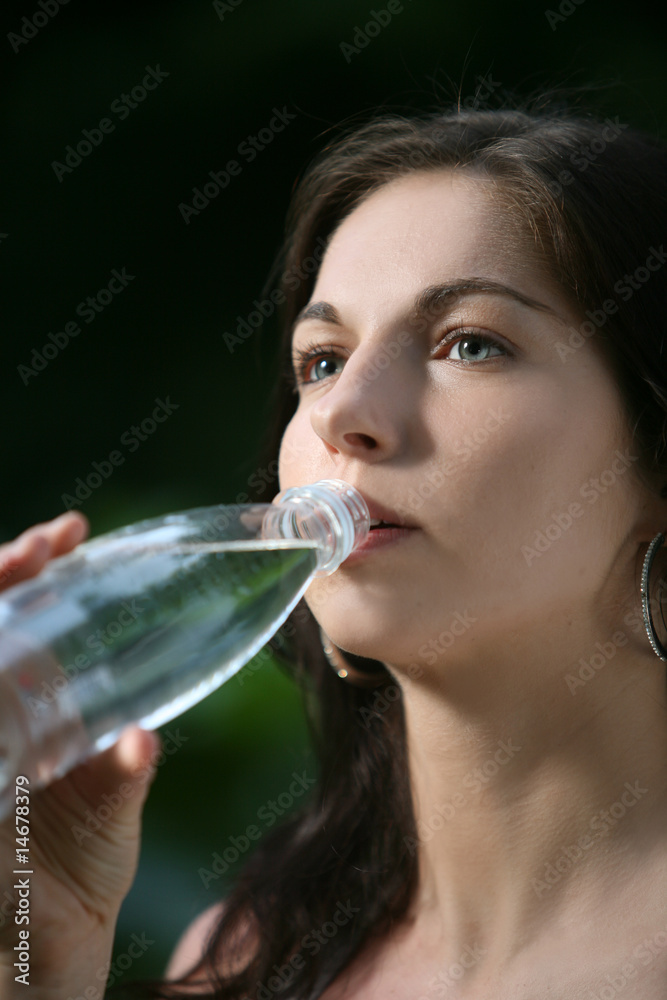 Beautiful young woman in the park. Drinks water. Beautiful young woman in the park. Drinks water.