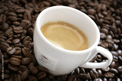 close-up of espresso cup with coffee beans around