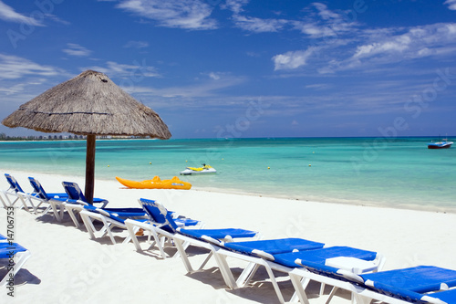 Tropical caribbean beach with chairs and umbrella