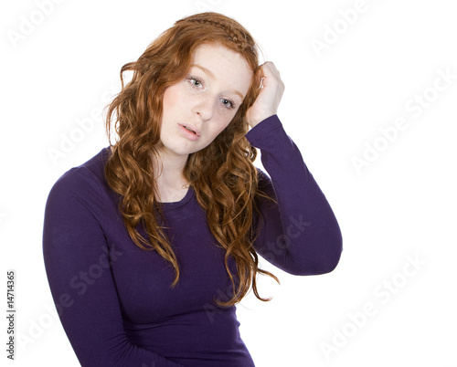 Shot of a Cute Red Headed Teen Scratching her Head photo