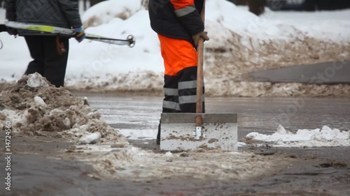 service man with shovel on winter street