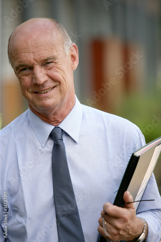 Bilde på lerret Portrait d'un homme senior souriant avec documents à la main
