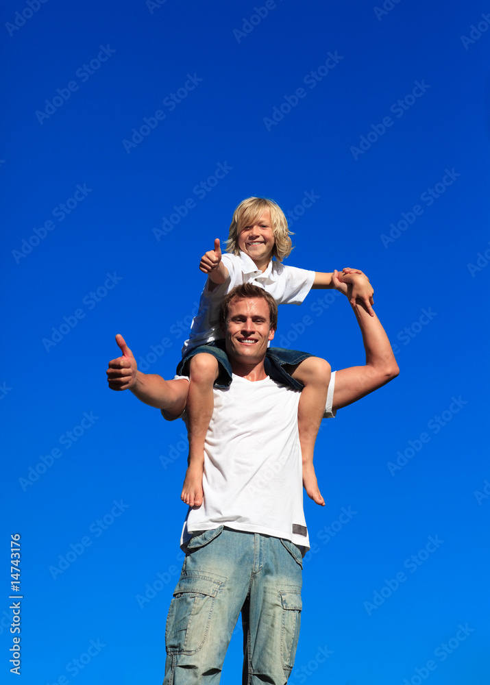 Kid on man's shoulders with thumbs up Kid on man's shoulders with thumbs up