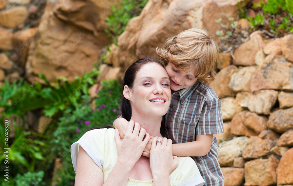 Son embracing his mother in a park Son embracing his mother in a park