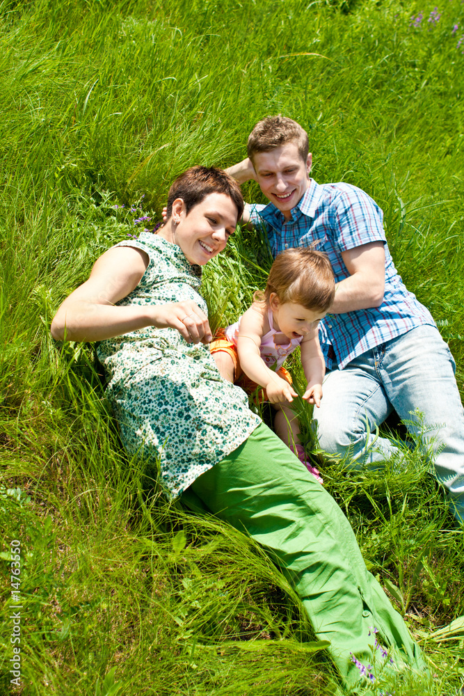 Obraz premium Family lying in grass